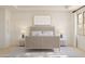 Well-lit main bedroom featuring white walls, carpet floors, and a decorative wood-framed bed at 7988 W Griswold Rd, Peoria, AZ 85345