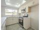 Bright kitchen with a view of the backyard features stainless appliances, and white cabinets at 838 W Duke Dr, Tempe, AZ 85283