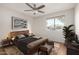 Cozy bedroom featuring a wood frame bed, plush carpet, and a view of the palm trees from the large window at 9355 N 91St St # 113, Scottsdale, AZ 85258