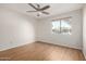 Spacious bedroom featuring wood floors, a ceiling fan, and a bright window with neighborhood views at 9355 N 91St St # 113, Scottsdale, AZ 85258