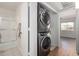 Hallway featuring a stacked washer and dryer near the bathroom and bedroom at 9355 N 91St St # 113, Scottsdale, AZ 85258