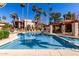 Community pool with clear blue water, surrounding palm trees, lounge chairs, and shaded seating area at 9355 N 91St St # 113, Scottsdale, AZ 85258