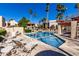 Community pool surrounded by lounge chairs and palm trees on a sunny day at 9355 N 91St St # 113, Scottsdale, AZ 85258