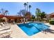 A community pool is surrounded by lounge chairs, a pergola, and mature trees for shade and relaxation at 9355 N 91St St # 113, Scottsdale, AZ 85258