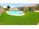 The backyard includes a kidney shaped pool, artificial turf, and a patio set at 9654 N 94Th Ave, Peoria, AZ 85345