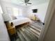 Bright bedroom featuring wood look floors, ceiling fan, and serene atmosphere at 9654 N 94Th Ave, Peoria, AZ 85345