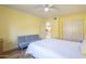 Bedroom with wood flooring, ceiling fan, bright yellow walls, and views to the kitchen at 1021 S Greenfield Rd # 1213, Mesa, AZ 85206