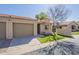 Exterior view of a home featuring a two-car garage, mature landscaping, and sidewalks at 1021 S Greenfield Rd # 1213, Mesa, AZ 85206