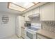 Well-lit kitchen featuring white appliances, tile backsplash, and ample cabinet space at 1021 S Greenfield Rd # 1213, Mesa, AZ 85206