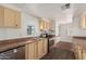 Kitchen with wooden cabinets, neutral countertops, stainless steel appliances, and modern vinyl flooring at 106 S 74Th St, Mesa, AZ 85208