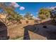 Exterior backyard featuring desert landscaping, block wall and a few shady trees at 1100 E Canyon Trl, San Tan Valley, AZ 85143