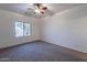 Carpeted bedroom featuring a ceiling fan and a window for natural light at 1100 E Canyon Trl, San Tan Valley, AZ 85143
