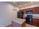 Functional kitchen featuring dark wooden cabinets, matching black appliances, and an island at 1100 E Canyon Trl, San Tan Valley, AZ 85143