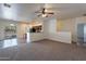 Inviting living room with plush carpeting, neutral walls, and open layout to kitchen and adjacent room at 1100 E Canyon Trl, San Tan Valley, AZ 85143