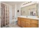 Bright bathroom featuring a shower-tub combo and a vanity with wood cabinets at 11069 E Kilarea Ave # 198, Mesa, AZ 85209