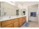 The main bathroom features a double vanity, well lit mirrors, and tile floors at 11069 E Kilarea Ave # 198, Mesa, AZ 85209