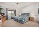 Cozy bedroom features a ceiling fan, comfortable bed, and a view of the neighborhood at 11069 E Kilarea Ave # 198, Mesa, AZ 85209