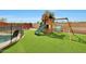 Backyard with green grass and a playset with swings and slide at 11652 N 49Th Dr, Glendale, AZ 85304