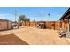 Expansive dirt backyard with a shed, dog house, and wooden fence at 11652 N 49Th Dr, Glendale, AZ 85304