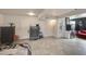 Open basement with tile flooring, multiple doors, and a mini fridge with room for storage at 11652 N 49Th Dr, Glendale, AZ 85304