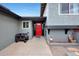 Gray house with a bright red front door and a small cart on the front entry concrete pad at 11652 N 49Th Dr, Glendale, AZ 85304
