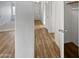 Hallway with light wood-style floors and white walls that leads to other rooms at 11734 W Paradise Dr, El Mirage, AZ 85335