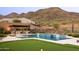 Inviting backyard with pool, BBQ island, putting green, and desert landscaping at 14102 E Sonora Crest Dr, Fountain Hills, AZ 85268