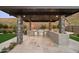 Entertainer's outdoor kitchen features a built-in BBQ, bar seating, and stone accents at 14102 E Sonora Crest Dr, Fountain Hills, AZ 85268