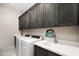 Functional laundry room with modern washer and dryer, sleek countertops, and ample storage cabinets at 14102 E Sonora Crest Dr, Fountain Hills, AZ 85268
