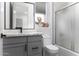 Bright bathroom featuring quartz countertops, gray cabinets with black hardware, toilet, and a shower at 1455 E Dove Pl, Casa Grande, AZ 85122