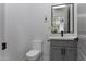 Powder room with quartz countertops, gray cabinets with black hardware, and a toilet at 1455 E Dove Pl, Casa Grande, AZ 85122
