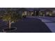 Dusk shot of landscaped front yard with accent lighting and circular driveway at 1455 E Dove Pl, Casa Grande, AZ 85122