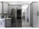 Open kitchen with stainless steel refrigerator and gray cabinets, leading to bathroom at 1455 E Dove Pl, Casa Grande, AZ 85122