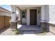 Inviting front porch with decorative stone pillars and a modern entry door at 14628 W Sand Hills Rd, Surprise, AZ 85387
