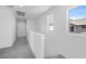 Bright upstairs hallway with gray carpeting and white walls, illuminated by two windows at 14628 W Sand Hills Rd, Surprise, AZ 85387