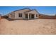Exterior of home, featuring a covered patio and views of the spacious backyard at 15822 W Bronco Trl, Surprise, AZ 85387