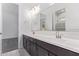 Bright bathroom featuring a double sink vanity, modern fixtures and a large mirror at 15822 W Bronco Trl, Surprise, AZ 85387