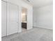 Bright bedroom with closet, view to bath, neutral carpet, modern fixtures and lighting at 15822 W Bronco Trl, Surprise, AZ 85387