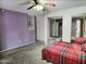 A bedroom featuring mirrored closet doors, carpeted floors, light purple walls, and a ceiling fan at 17648 N 36Th St, Phoenix, AZ 85032