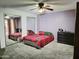 A bedroom featuring mirrored closet doors, carpeted floors, light purple walls, and a ceiling fan at 17648 N 36Th St, Phoenix, AZ 85032