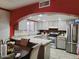 A kitchen features stainless steel appliances, gray-washed cabinetry, granite counters and opens to a dining area at 17648 N 36Th St, Phoenix, AZ 85032