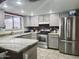 A kitchen featuring stainless steel appliances, gray-washed cabinetry, granite counters, and a light tile floor at 17648 N 36Th St, Phoenix, AZ 85032