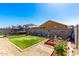 Landscaped backyard featuring a patch of artificial grass, a trampoline, and a garden bed at 18069 W Tina Ln, Surprise, AZ 85387