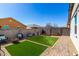 Fully enclosed backyard with artificial turf sections, mature landscaping, and hardscaped patio at 18069 W Tina Ln, Surprise, AZ 85387