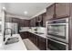 Modern kitchen featuring stainless steel appliances, dark wood cabinetry, and white countertops at 18069 W Tina Ln, Surprise, AZ 85387