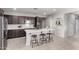 Bright kitchen featuring a large island with bar stool seating, stainless steel appliances, and dark wood cabinets at 18069 W Tina Ln, Surprise, AZ 85387