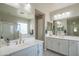 Bright bathroom with dual sinks, white cabinets, tub and shower with a view at 18187 W Via Montoya Dr, Surprise, AZ 85387