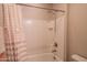 Clean white bathtub and shower combination with a striped curtain and silver fixtures at 18187 W Via Montoya Dr, Surprise, AZ 85387