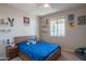 Comfortable bedroom with blue comforter, window, ceiling fan, and sports-themed decor at 18187 W Via Montoya Dr, Surprise, AZ 85387