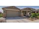 Charming home featuring a two-car garage, a covered front porch and manicured landscaping at 18187 W Via Montoya Dr, Surprise, AZ 85387
